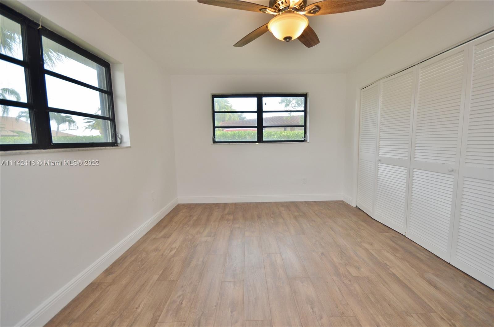 6760 Royal Melbourne Drive Hialeah, FL 33015 - Photo 32 of 36 a view of an empty room with wooden floor and a window