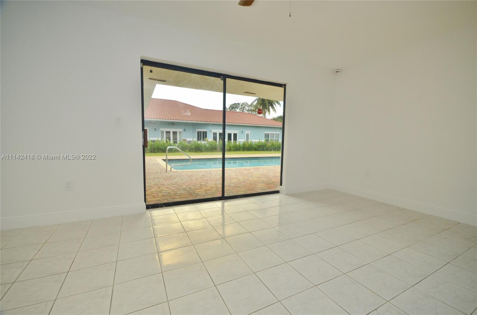 6760 Royal Melbourne Drive Hialeah, FL 33015 - Photo 34 of 36 an empty room with sliding glass door