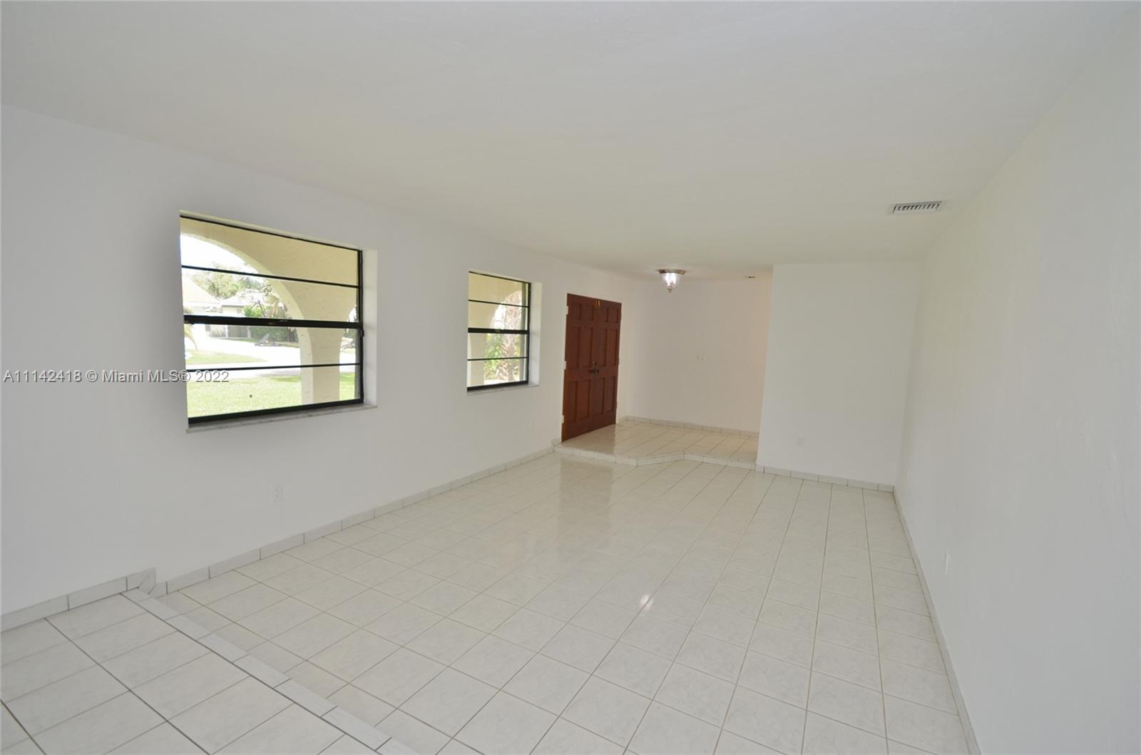 6760 Royal Melbourne Drive Hialeah, FL 33015 - Photo 4 of 36 an empty room with windows