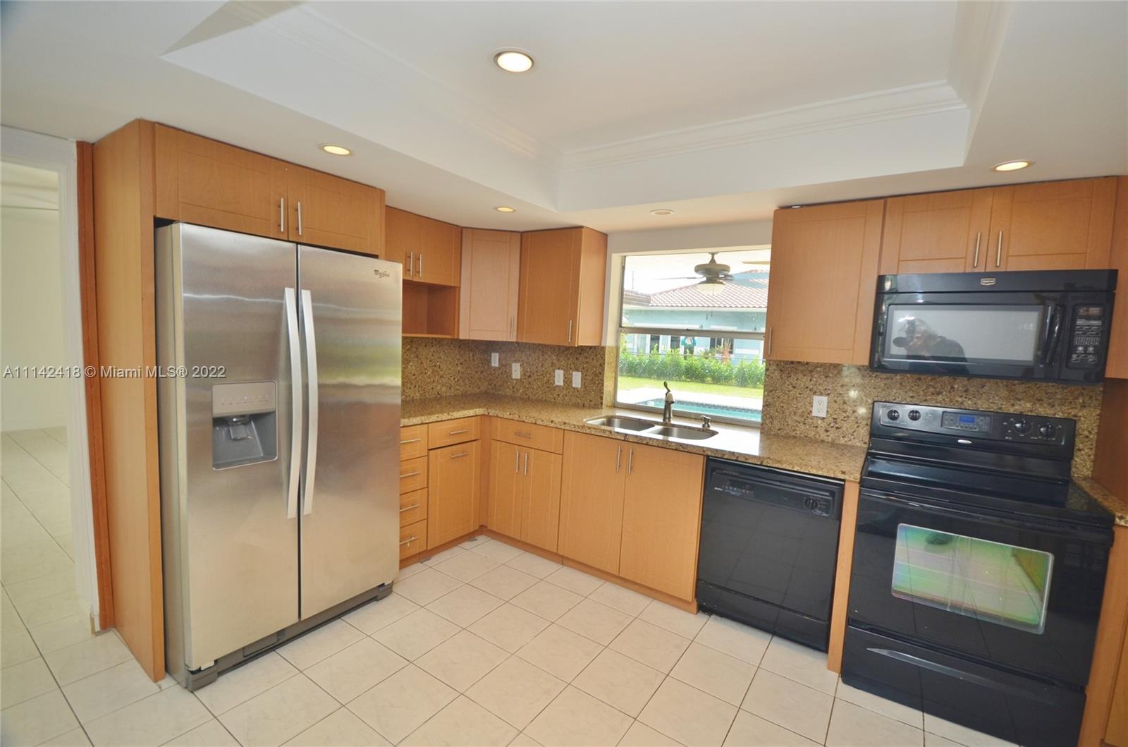 6760 Royal Melbourne Drive Hialeah, FL 33015 - Photo 8 of 36 a kitchen with stainless steel appliances granite countertop a refrigerator and a stove top oven