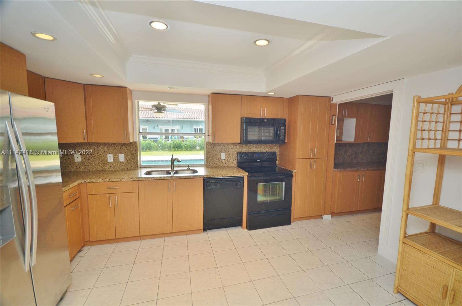 6760 Royal Melbourne Drive Hialeah, FL 33015 - Photo 10 of 36 a kitchen with granite countertop a refrigerator stove top oven and sink