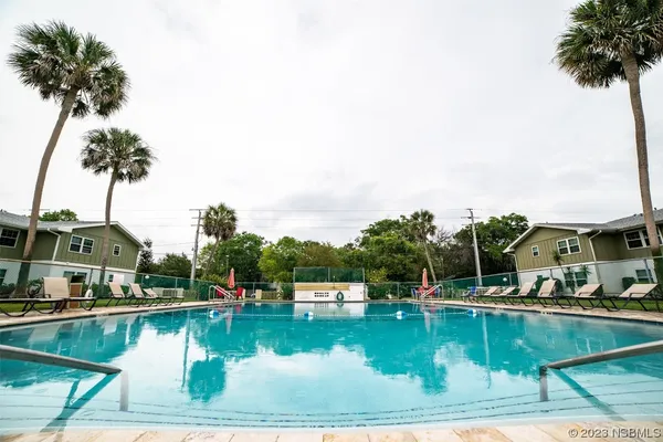 a view of swimming pool with outdoor seating and lake view