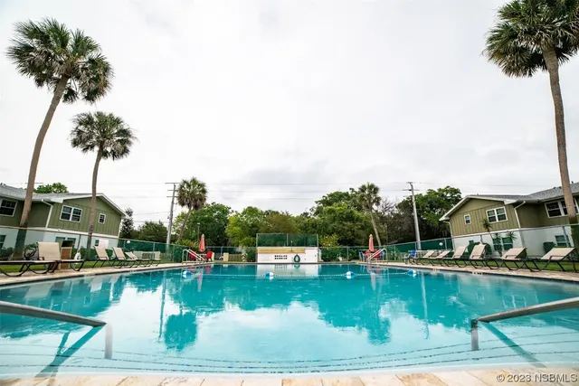 a view of swimming pool with outdoor seating and lake view
