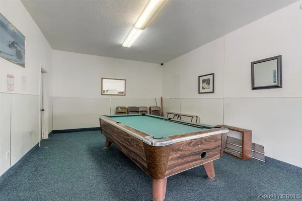 a room with pool table and windows
