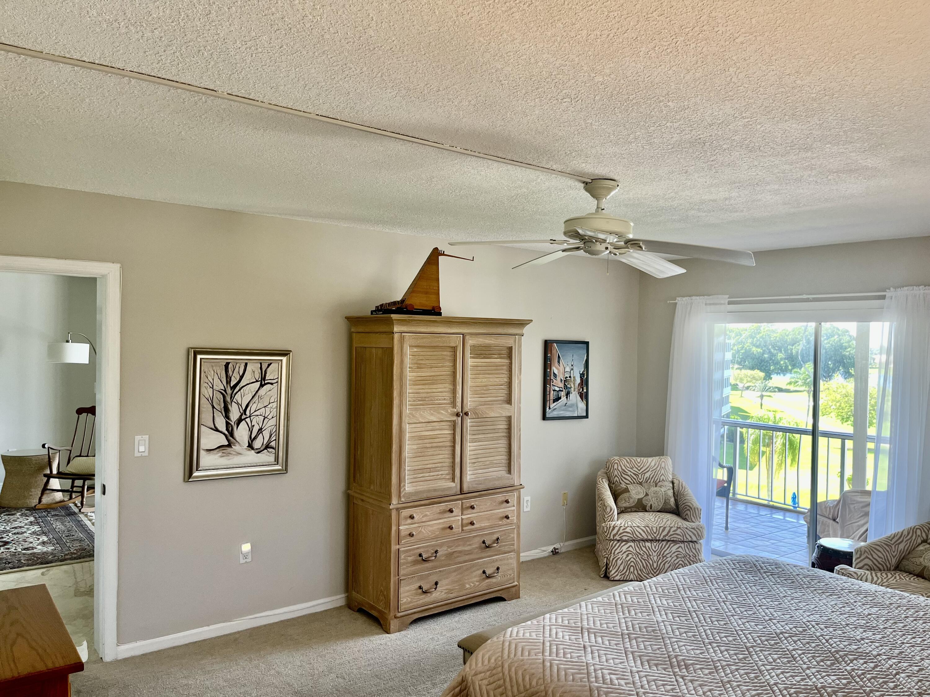 145 Atlantis Boulevard, Unit PH4 Atlantis, FL 33462 - Photo 13 of 27 a bedroom with a bed and a window