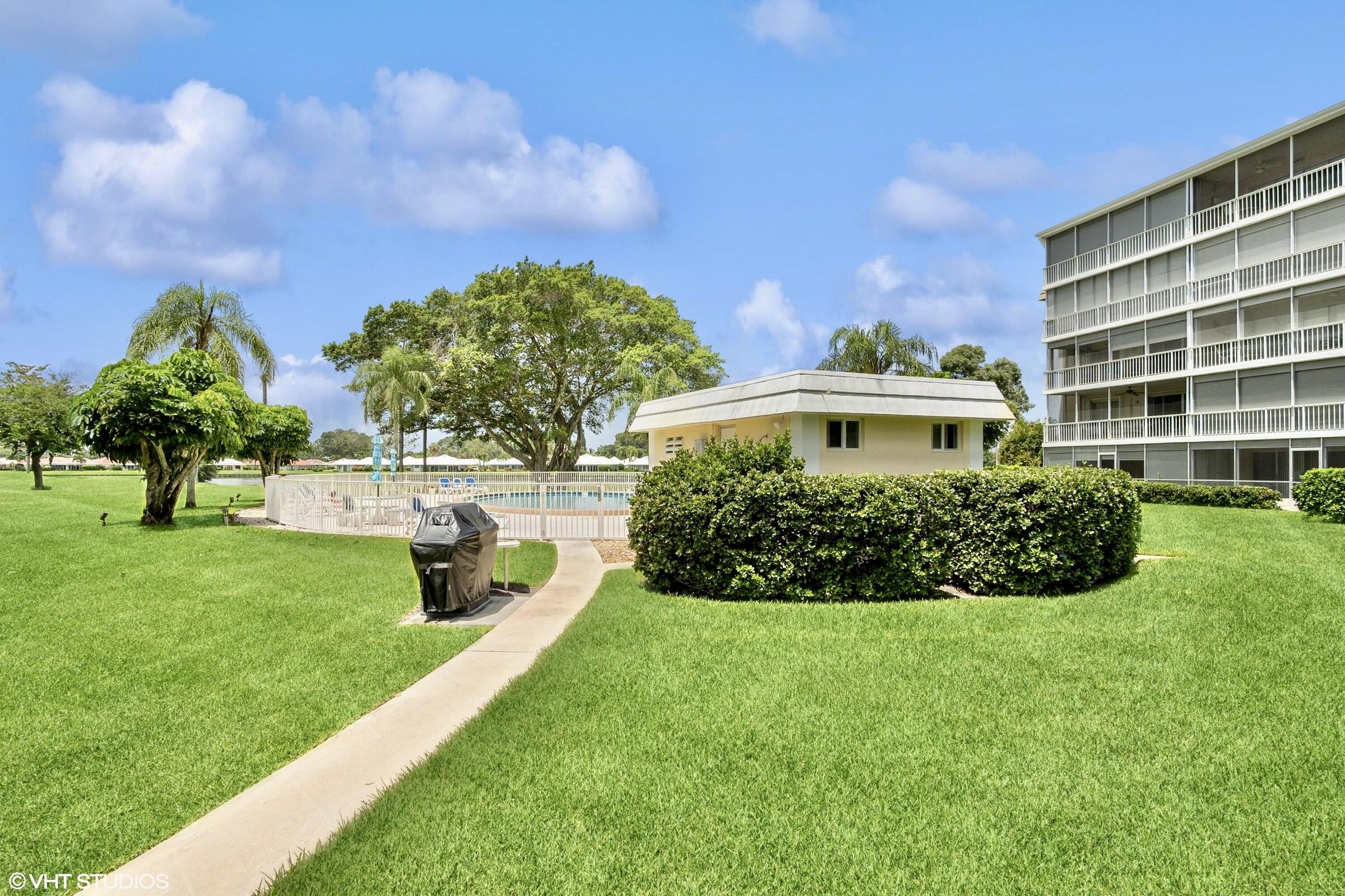 145 Atlantis Boulevard, Unit PH4 Atlantis, FL 33462 - Photo 26 of 27 a view of a garden with a building in the background