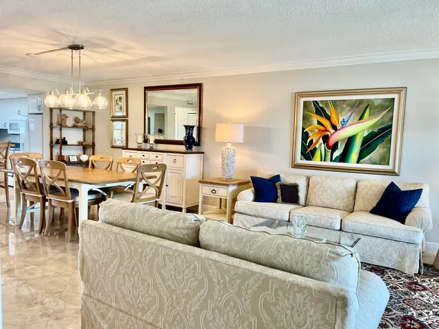 a dining room with furniture a chandelier and kitchen view