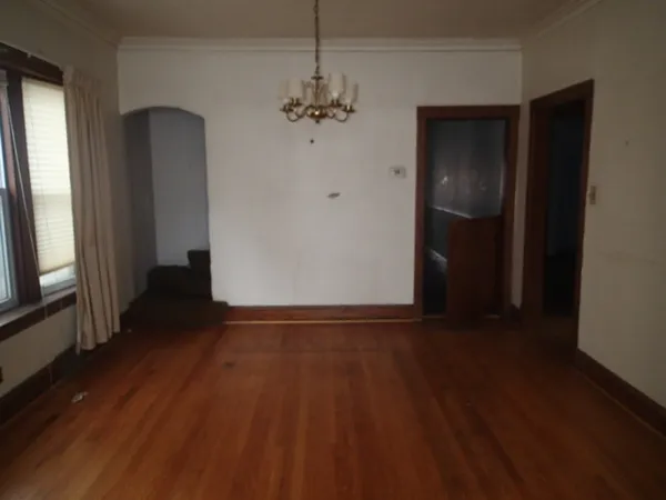 a view of a hallway with wooden floor and stairs