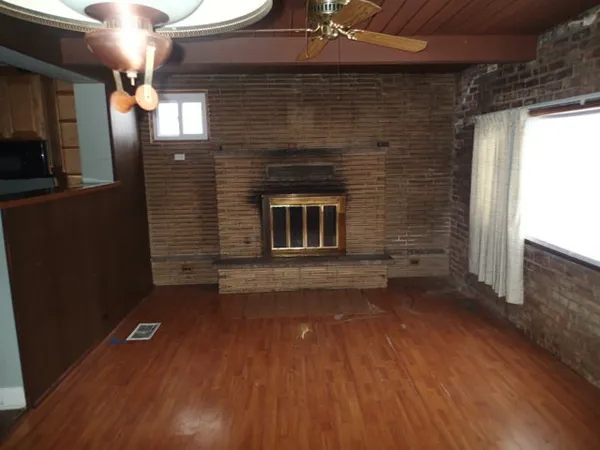 an empty room with wooden floor and fireplace