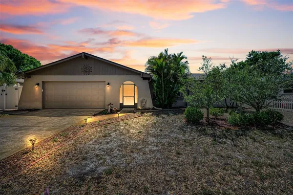 a view of a house with a yard and large tree