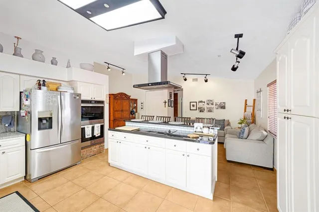 a kitchen with stainless steel appliances kitchen island granite countertop a refrigerator and a stove