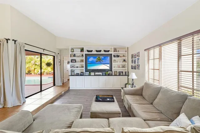 a living room with furniture a large window and a flat screen tv