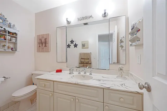 a bathroom with a toilet sink and mirror