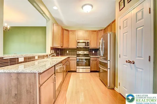 a kitchen with stainless steel appliances granite countertop a stove a sink and a refrigerator