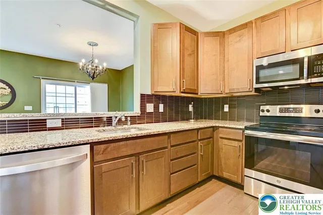 a kitchen with stainless steel appliances granite countertop a stove a sink and a microwave
