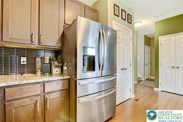 a kitchen with stainless steel appliances granite countertop a refrigerator and a stove