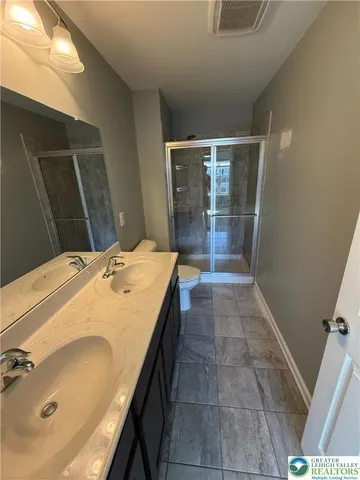 a bathroom with a tub a sink and glass door