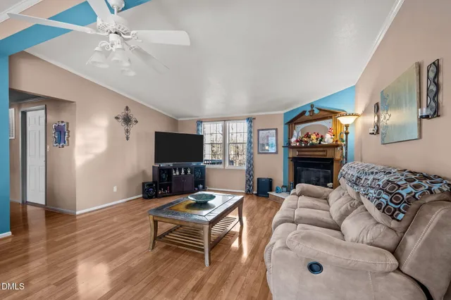 a living room with furniture a flat screen tv and a fireplace