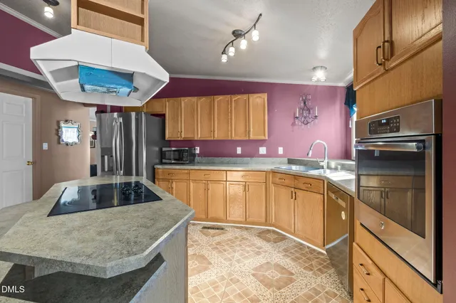 a kitchen with granite countertop a sink a counter space appliances and cabinets