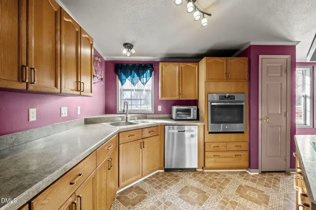 a kitchen with stainless steel appliances granite countertop a stove a refrigerator a kitchen island a dining table and chairs with wooden floor