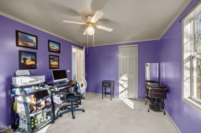 a view of a workspace with furniture and a window