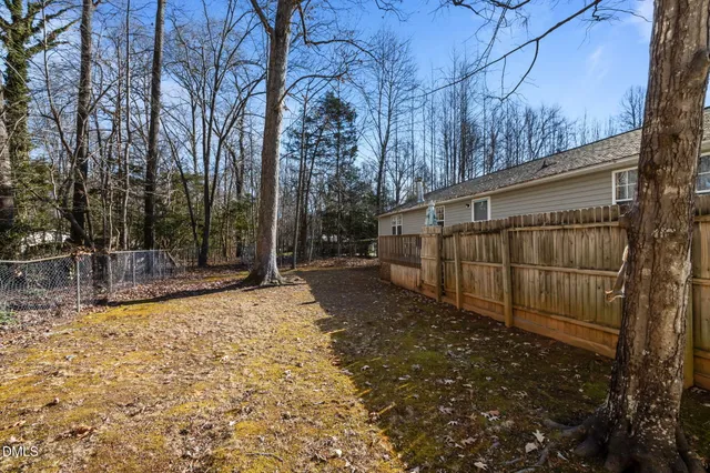 a view of a house with a small yard and wooden fence