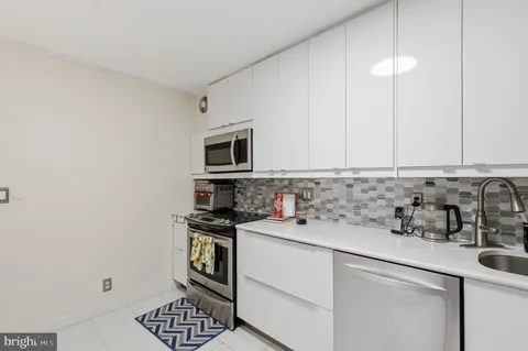 a kitchen with a sink a stove and cabinets