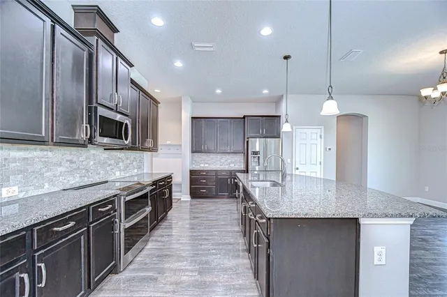 a large kitchen with kitchen island a large island in it