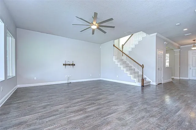 a view of a livingroom with wooden floor and a ceiling fan