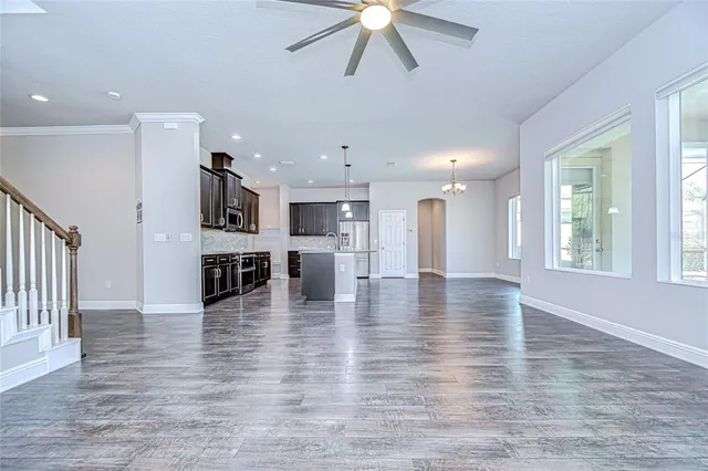 a large kitchen with stainless steel appliances kitchen island a large island wooden cabinets and a wooden floor