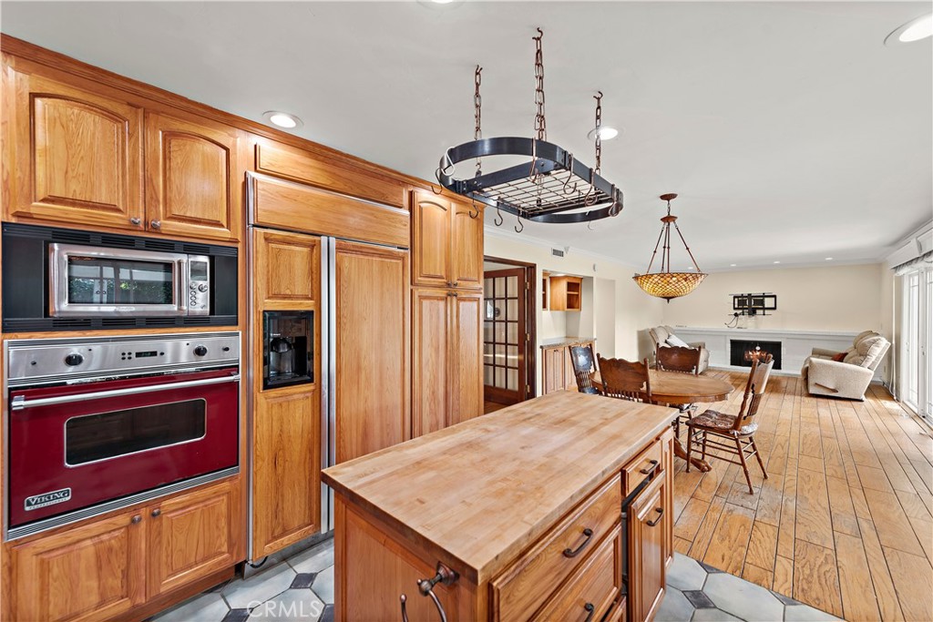 24372 Barbados Drive Dana Point, CA 92629 - Photo 12 of 39 a kitchen with stainless steel appliances granite countertop a stove a refrigerator a kitchen island a sink dishwasher a dining table and chairs with wooden floor