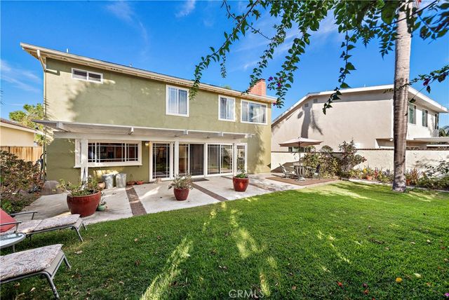 a view of a house with backyard sitting area and garden