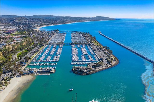 a view of a city with lots of residential buildings ocean and mountain in the back
