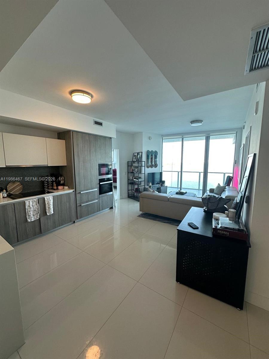 2900 Northeast 7th Avenue, Unit 1003 Miami, FL 33137 - Photo 5 of 15 a living room with furniture and a flat screen tv
