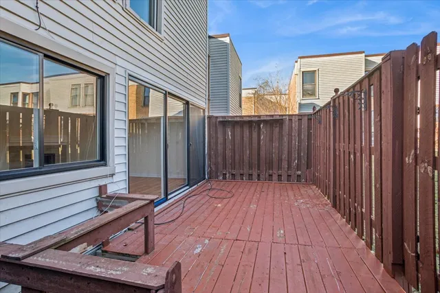 a view of backyard with wooden floor and fence