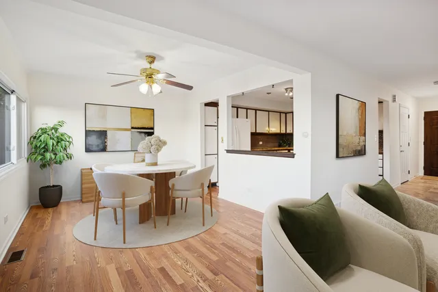a living room with furniture a dining table and a potted plant