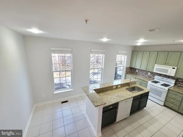 a kitchen with stainless steel appliances granite countertop a sink and a stove