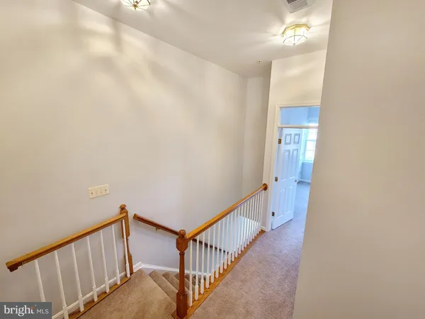 a view of a hallway with wooden floor and entryway