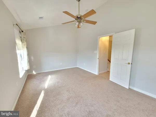 a view of a livingroom with a ceiling fan and window