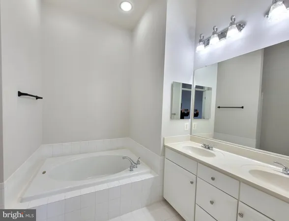 a bathroom with a tub sink shower and mirror