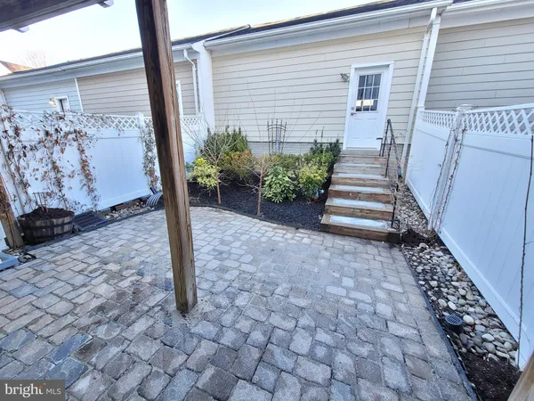 a view of a pathway of house with wooden fence