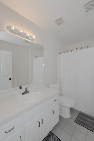a bathroom with a double vanity sink toilet and a mirror