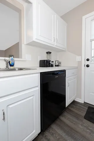 a kitchen with white cabinets and sink