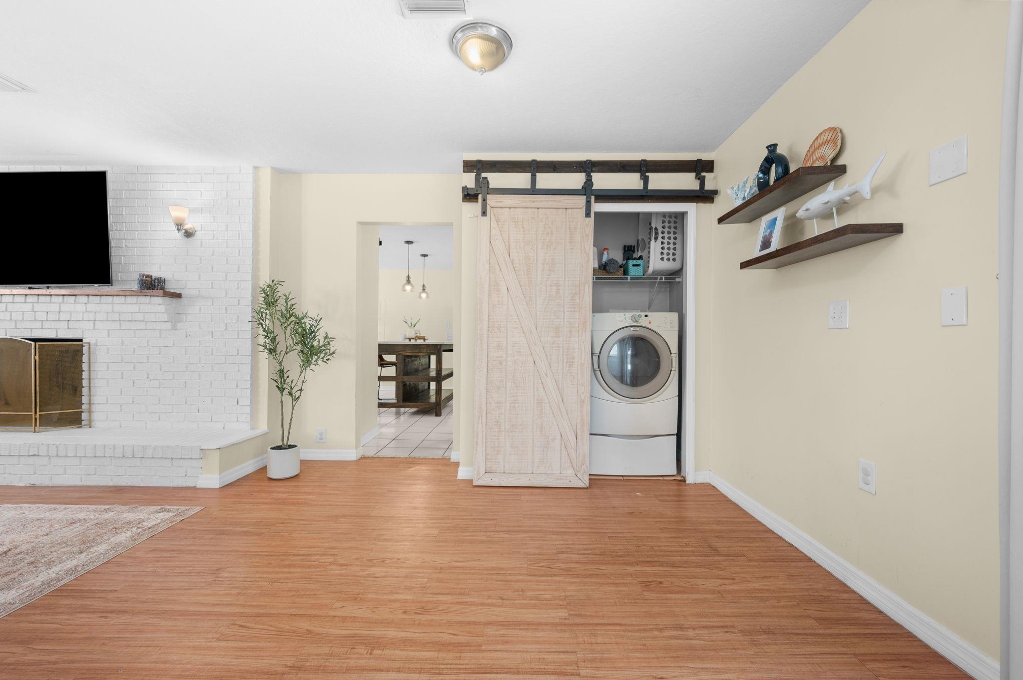 4233 Oak Lane St. Augustine, FL 32086 - Photo 17 of 42 Laundry area with a barn door, washer / dryer, and light wood-style flooring