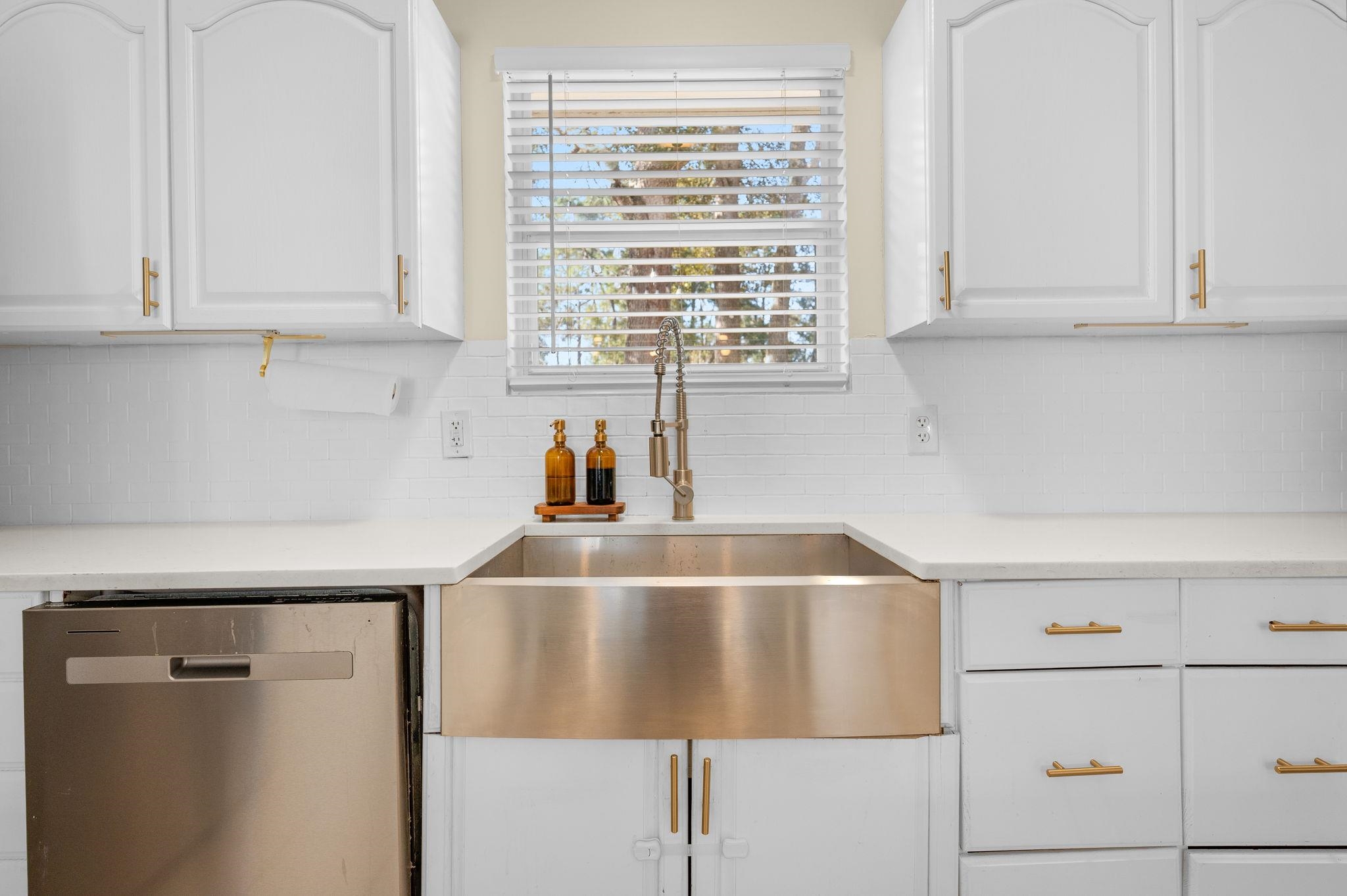 4233 Oak Lane St. Augustine, FL 32086 - Photo 21 of 42 Kitchen with white cabinets, stainless steel dishwasher, tasteful backsplash, and light stone counters