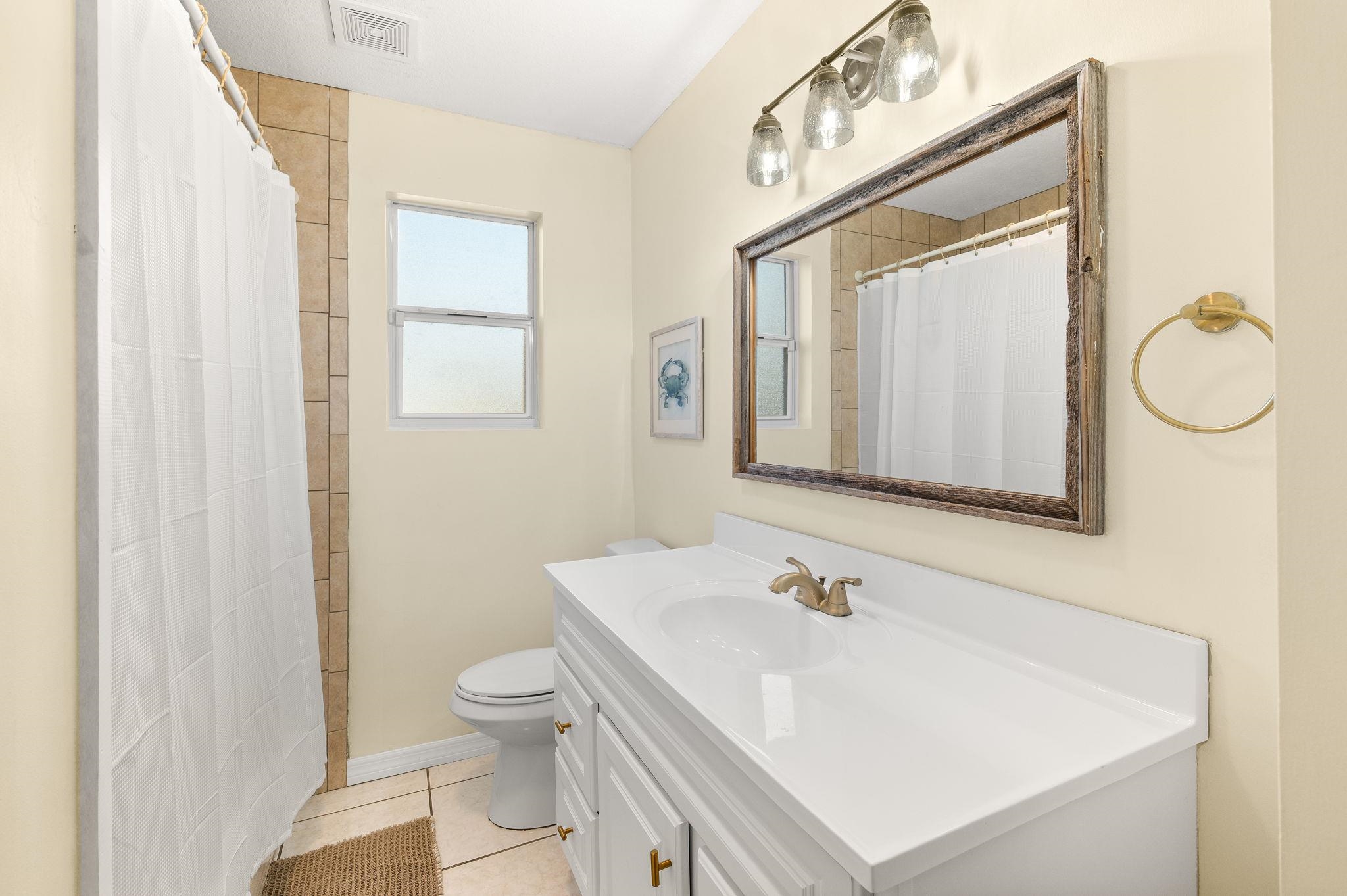 4233 Oak Lane St. Augustine, FL 32086 - Photo 30 of 42 Bathroom featuring vanity, curtained shower, and light tile patterned floors