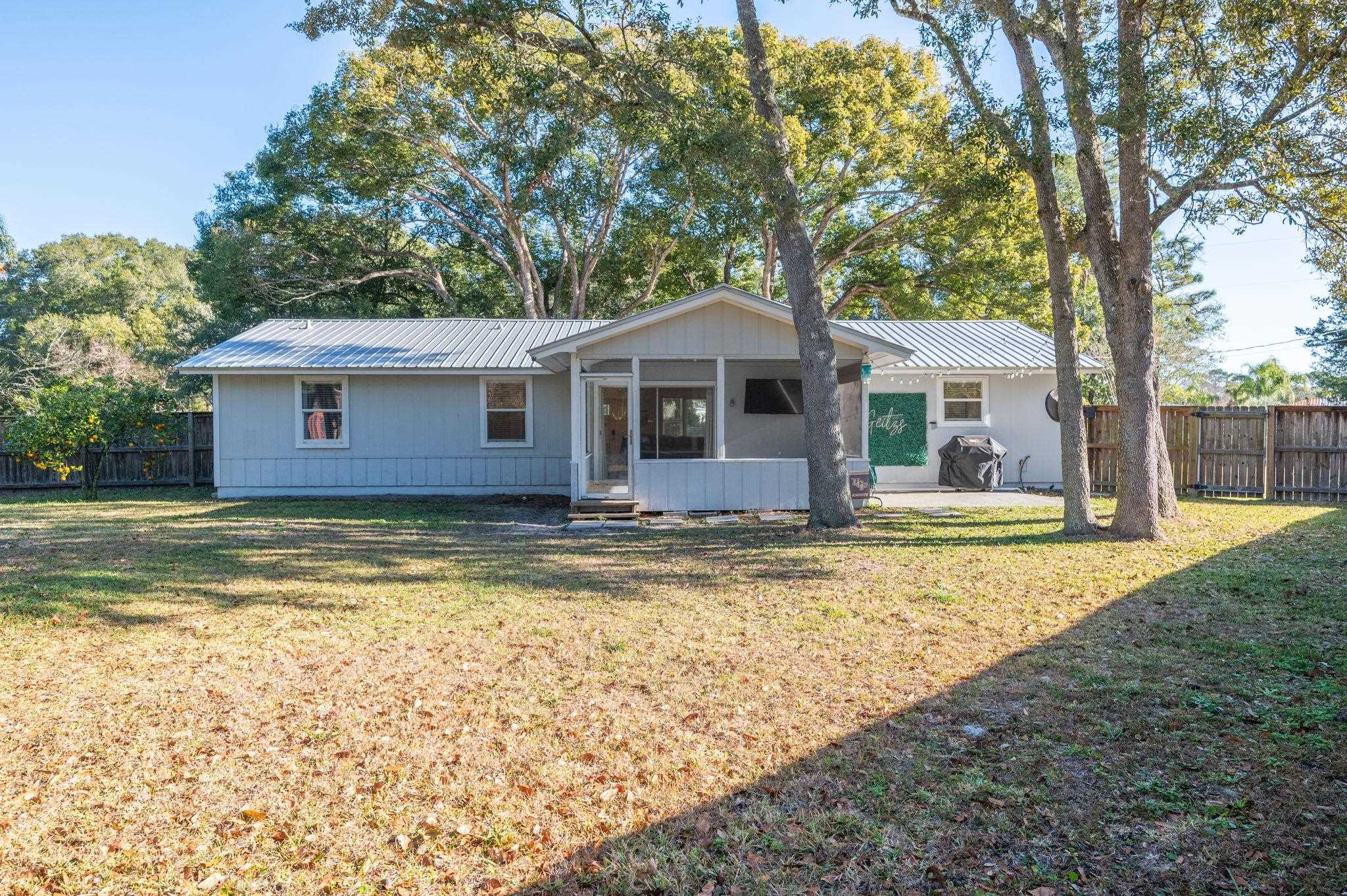 4233 Oak Lane St. Augustine, FL 32086 - Photo 40 of 42 View of front of house with a metal roof, a sunroom, and a patio