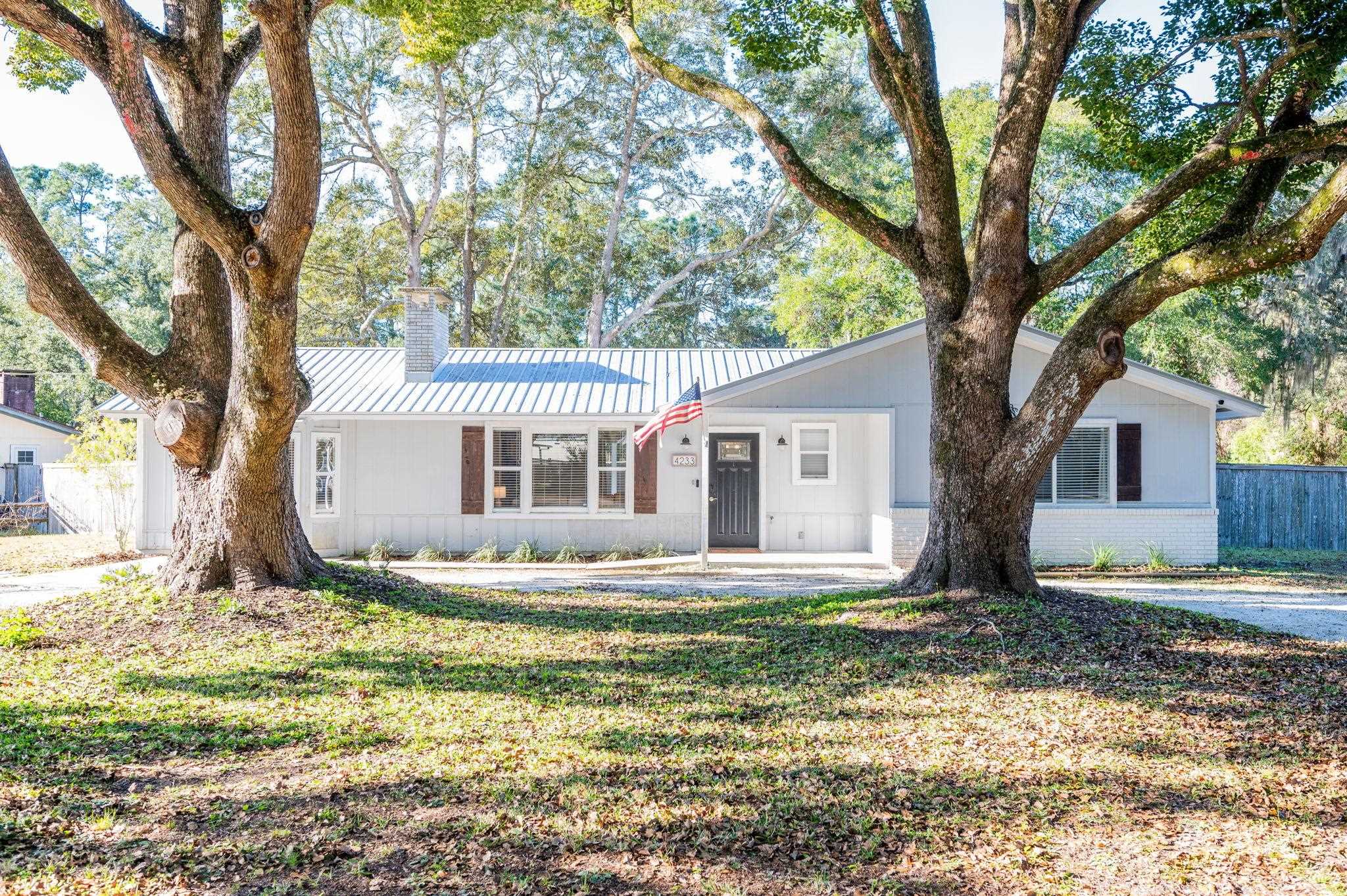 4233 Oak Lane St. Augustine, FL 32086 - Photo 4 of 42 Ranch-style house featuring a metal roof, a chimney, and brick siding