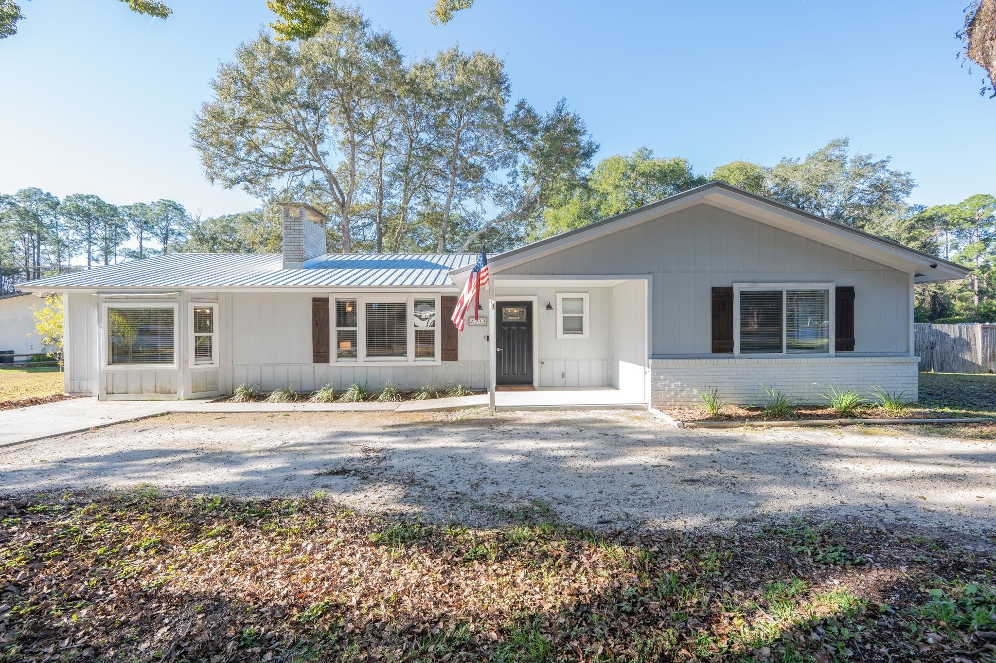 4233 Oak Lane St. Augustine, FL 32086 - Photo 5 of 42 Ranch-style house featuring brick siding, a chimney, and a metal roof