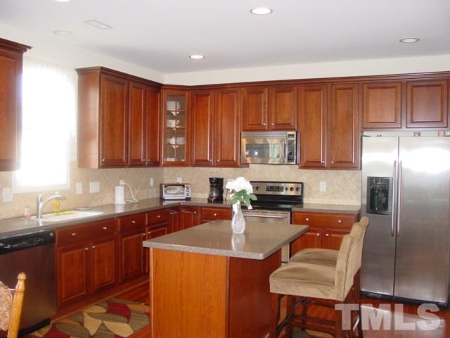 5212 Holly Ridge Farm Road Raleigh, NC 27616 - Photo 2 of 3 a kitchen with stainless steel appliances granite countertop a sink refrigerator and microwave